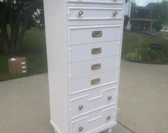May include: White chest of drawers with six drawers and gold-toned hardware. The chest is made of wood and has a simple, elegant design.