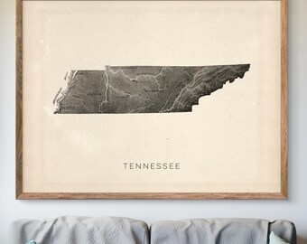 May include: A framed print of a black and white map of Tennessee. The map is detailed and shows the state's rivers and mountains. The word "Tennessee" is printed below the map.