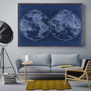 May include: A vintage world map print in blue and white, framed in brown wood, hangs above a gray sofa and a wooden chair with a black cushion. A black tripod lamp with a round shade is in the corner of the room.