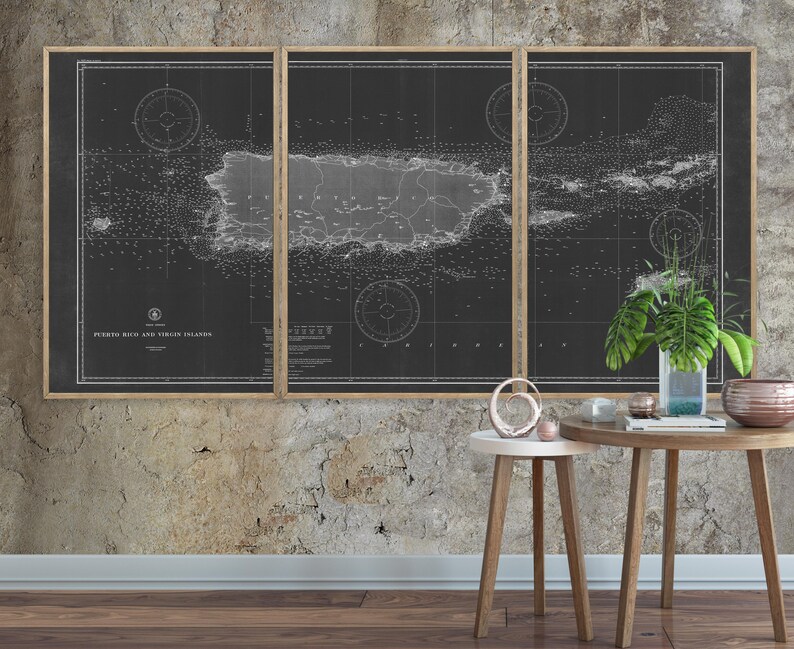 May include: A black and white vintage map of Puerto Rico and the Virgin Islands, framed in a wooden frame. The map is displayed on a textured wall with two small wooden tables and decorative objects.