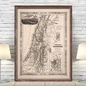 May include: A vintage map of Palestine, titled "Johnson's Palestine", showing the journey of Jesus and Paul. The map is printed in black and white on a cream-colored paper and framed in a brown wood frame.