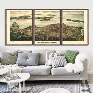 May include: A vintage map of Sandusky, Ohio, divided into three panels. The map shows the city's streets, buildings, and waterways. The map is printed in shades of green, brown, and blue. The title "Sandusky, Ohio" is printed in red at the bottom center of the map.