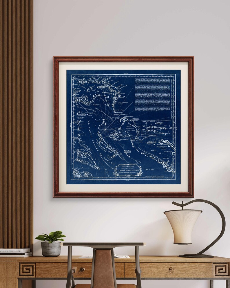 Puede incluir: Un mapa n&aacute;utico vintage del Mar Caribe, impreso en blanco sobre un fondo azul oscuro. El mapa muestra las islas del Caribe, incluyendo Cuba, Jamaica y Puerto Rico. El mapa est&aacute; enmarcado en un marco de madera oscura.