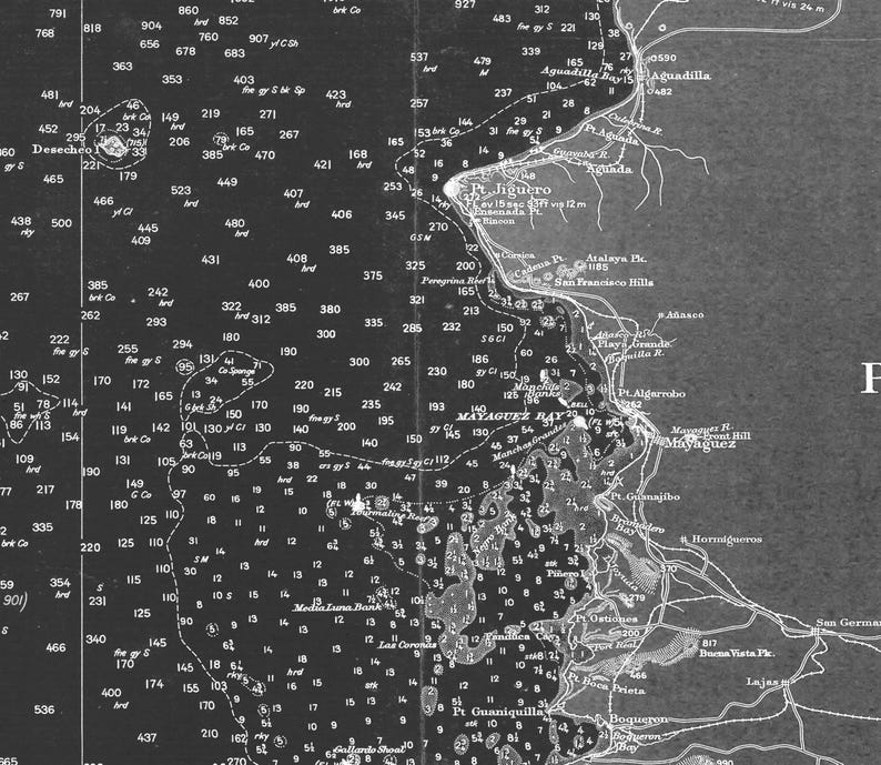 May include: A black and white map of the coast of Puerto Rico, showing the location of Mayaguez Bay and surrounding areas. The map includes depth soundings, navigational aids, and other important features for mariners.