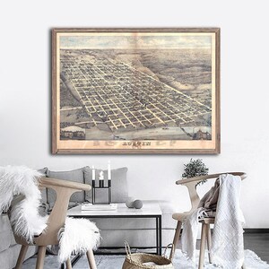 May include: A vintage map of Austin, Texas, printed in sepia tones and framed in a light brown wood frame. The map shows the city's layout in detail, with streets, buildings, and landmarks clearly marked. The title "Austin, Texas" is printed at the bottom of the map.