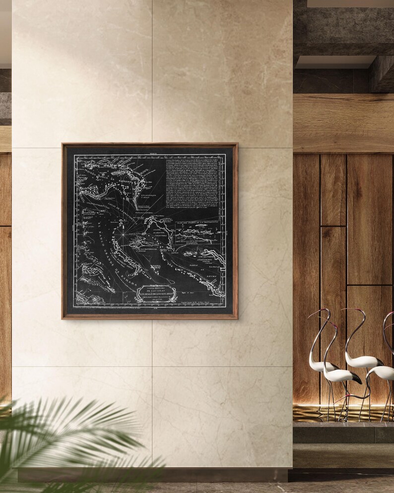 Puede incluir: Un mapa de color negro enmarcado del Mar Caribe con l&iacute;neas y texto blancos. El mapa est&aacute; colgado en una pared beige con un panel de madera a la derecha.