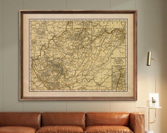 May include: A framed vintage map of West Virginia, featuring detailed geographical information in black lines on a tan background. The map is enclosed in a dark brown wooden frame, suitable for home decor.