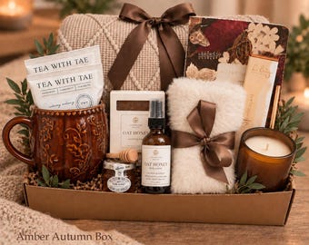 May include: A gift box containing a brown embossed mug with Tea With Tae packets, a jar of honey, a wooden dipper, an Oat Honey lotion bottle, a small soap bar, a fuzzy white cloth with a brown ribbon, a chocolate bar, and a floral notebook.