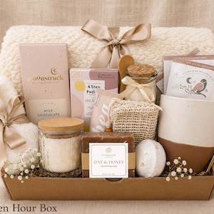 Puede incluir: Una cesta de regalo que contiene una manta texturizada de color crema con una cinta de sat&eacute;n, una barra de chocolate con leche Moonstruck, un kit de pedicura de 4 pasos, un frasco de vidrio con tapa de corcho, una taza, una cuchara dorada y jab&oacute;n de avena y miel.