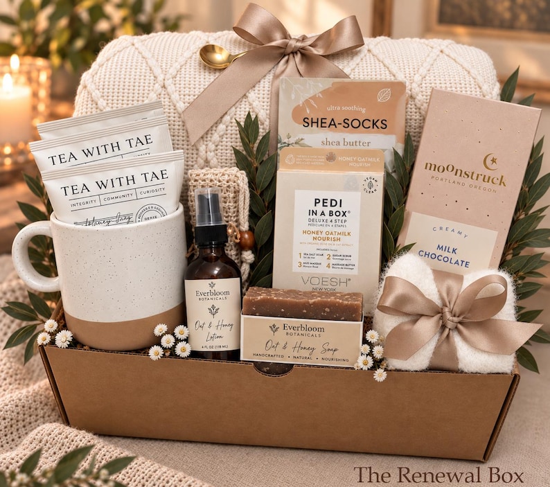 May include: A gift box containing a speckled ceramic mug with Tea With Tae packets, a bottle of Everbloom Botanicals Oat & Honey Lotion, a bar of Oat & Honey Soap, a Voesh Pedi In A Box kit, Shea-Socks, and a Moonstruck milk chocolate bar.