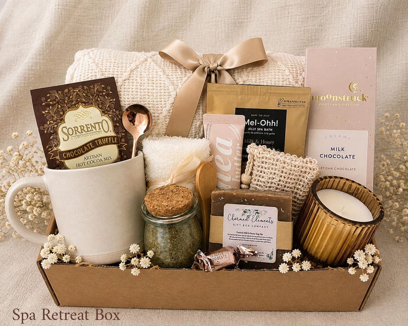 Puede incluir: Una caja de regalo que contiene una taza de cer&aacute;mica blanca, un paquete de mezcla de chocolate caliente Sorrento, una cuchara dorada, una manta de punto color crema con lazo de sat&eacute;n, un frasco de sales de ba&ntilde;o, jab&oacute;n, una vela y chocolate con leche Moonstruck.