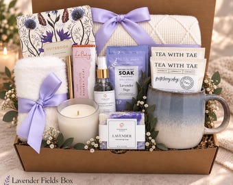 May include: A gift box containing a floral notebook, a white textured blanket with a lavender ribbon, a gold pen, a dark chocolate bar, a lavender vanilla spray, lavender sea salt soak, two tea bags, a white candle, and a lavender soap bar.