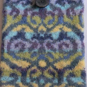 May include: A blue, green and yellow knitted phone case with a black button.