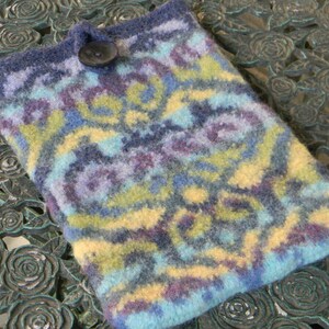 May include: A blue, yellow and purple knitted phone case with a decorative button.