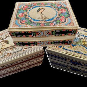Puede incluir: Tres cajas decorativas vintage con intrincados diseños florales y detalles dorados. La caja superior presenta a una mujer con un vestido blanco, la caja del medio tiene un patrón floral y la caja inferior presenta a un grupo de mujeres con vestidos coloridos.