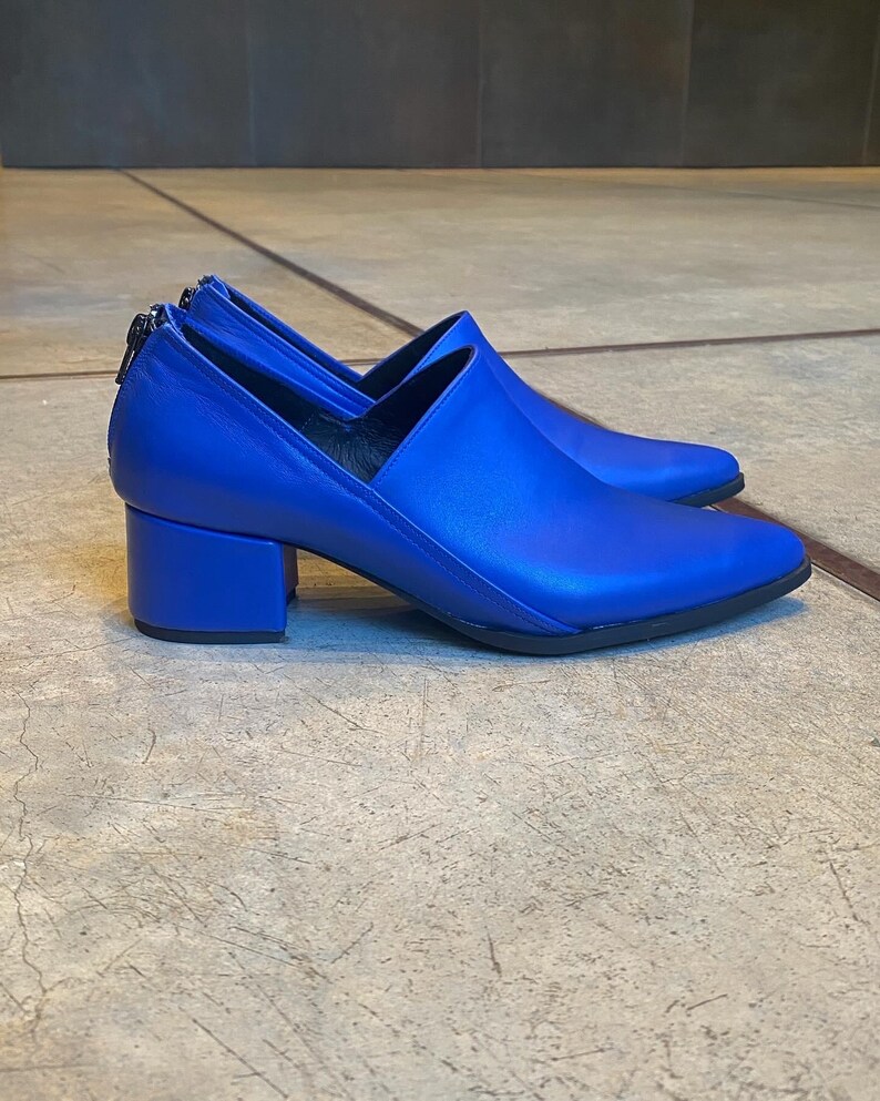 May include: A pair of bright blue leather heeled shoes with a pointed toe and a block heel.