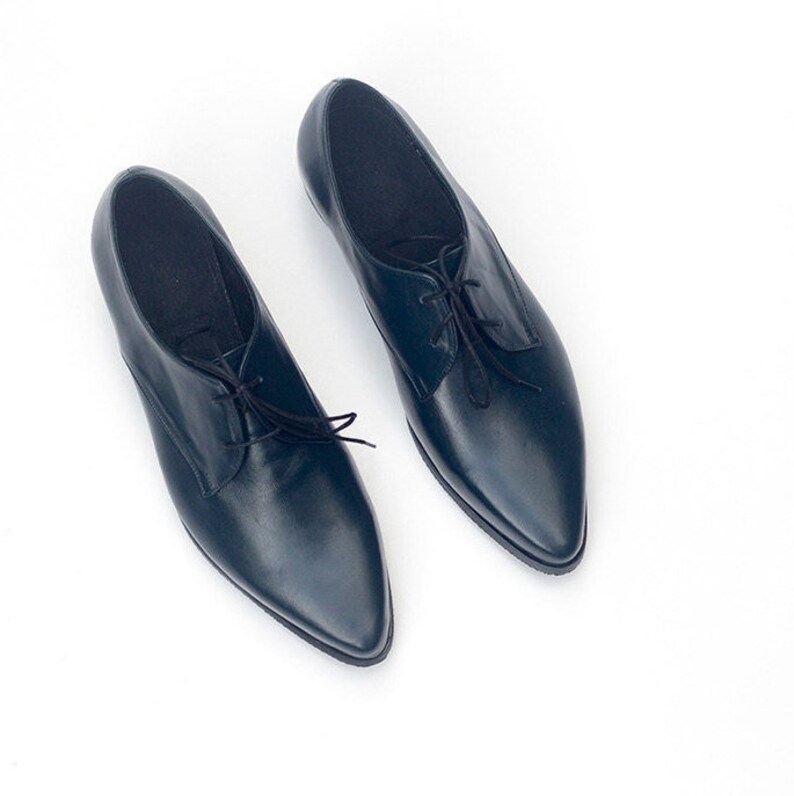 May include: A pair of dark blue leather lace-up shoes with pointed toes.