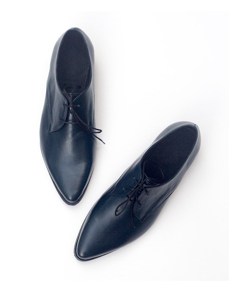 May include: A pair of dark blue leather lace-up shoes with pointed toes.