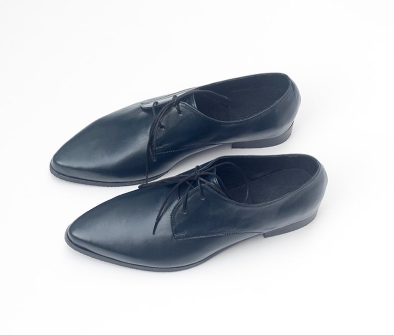 May include: A pair of dark blue leather lace-up shoes with pointed toes.