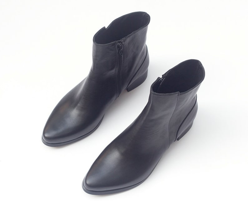 May include: A pair of black leather ankle boots with pointed toes and zipper closures.
