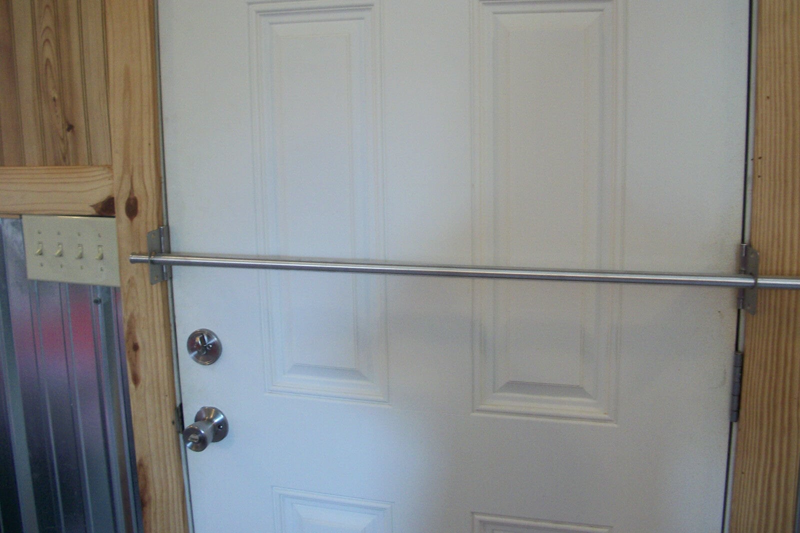 una barra de seguridad de bloqueador de puerta en uso reforzando el puerta  blanca de una casa desde dentro Fotografía de stock - Alamy