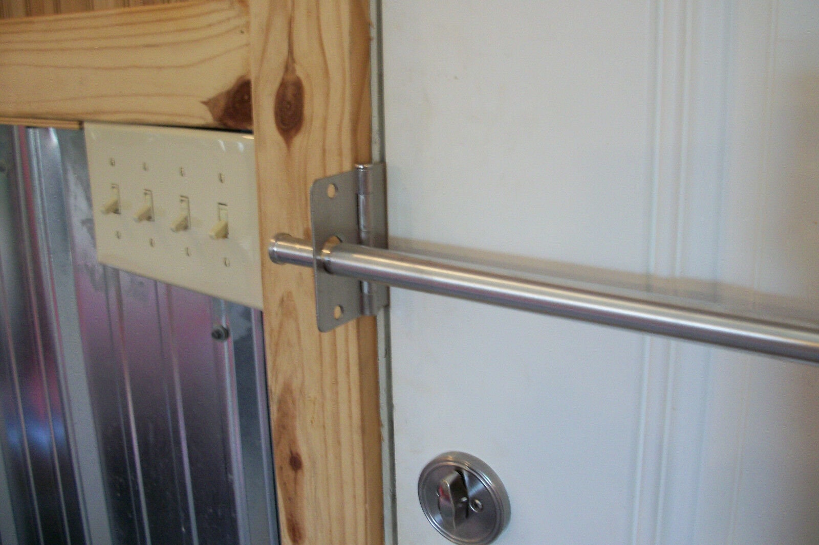 una barra de seguridad de bloqueador de puerta en uso reforzando el puerta  blanca de una casa desde dentro Fotografía de stock - Alamy