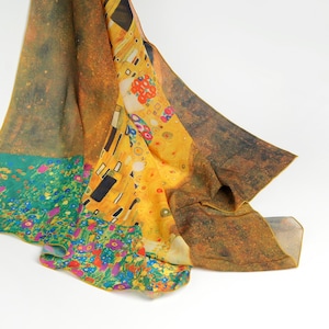May include: A yellow, green, and blue silk scarf with a printed image of Gustav Klimt's "The Kiss" painting.