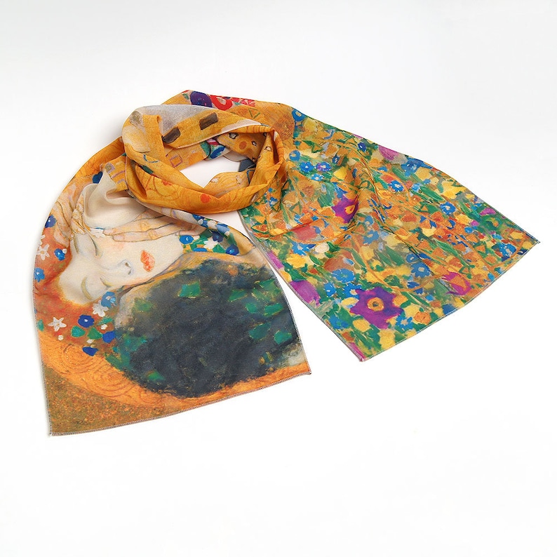 May include: A yellow silk scarf with a floral pattern on one side and a painting of a couple kissing on the other side.