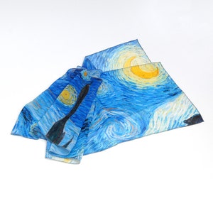 Puede incluir: Una bufanda de seda azul y amarilla con un patr&oacute;n de remolinos que recuerda a la pintura "La noche estrellada" de Vincent van Gogh.