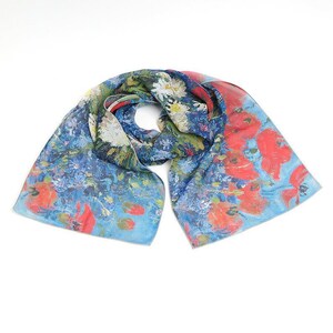 May include: A blue and red silk scarf with a floral print. The scarf features a painting of red poppies and white daisies.