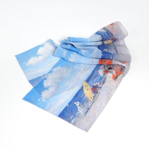 May include: A light blue scarf with a beach scene print. The scarf features a sky with white clouds, a blue ocean, and figures with umbrellas. The scarf is made of a lightweight material.