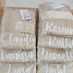 a collection of beige fabric items, likely to be used as clothing or accessories, neatly arranged on a wooden surface.