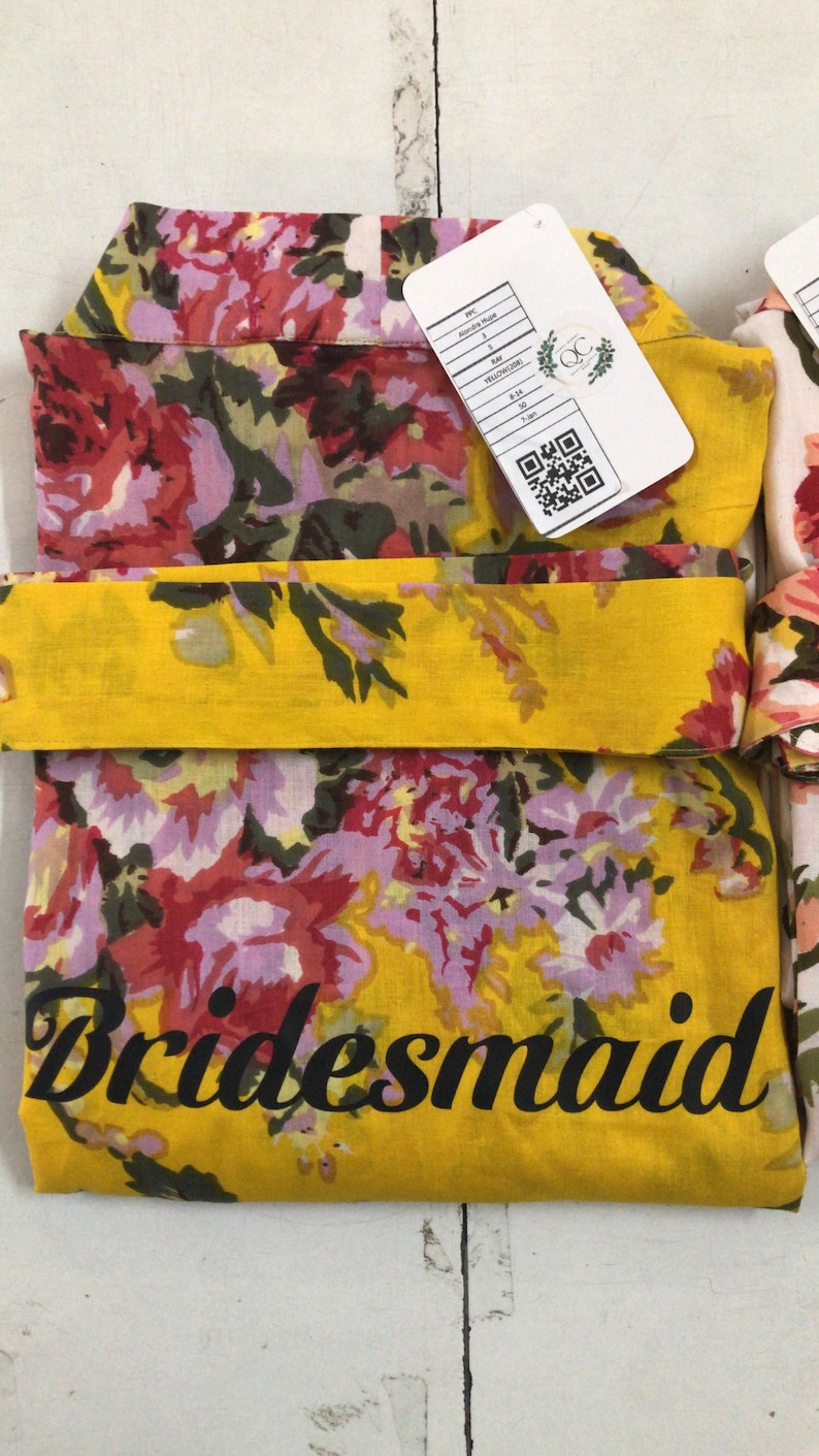 a yellow scarf with flowers and a tag on it