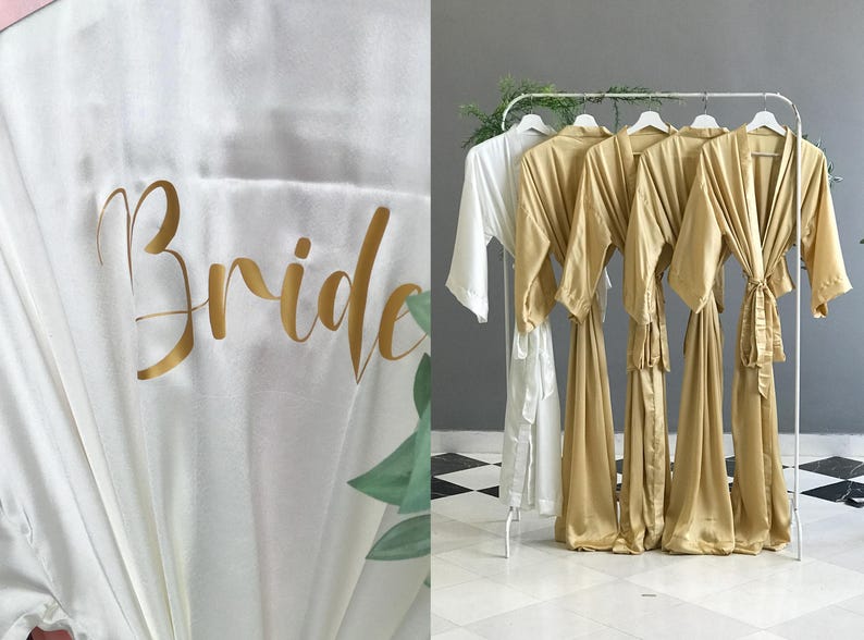 The image is a collage of two photos. The left photo shows a close-up of a white robe with the word "Bride" written on it in gold cursive text. The right photo depicts a row of gold satin robes hanging on a rack.