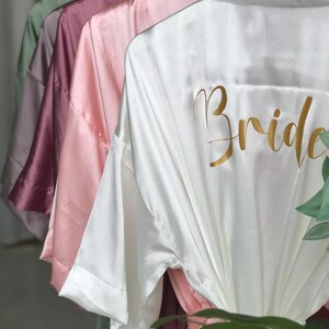 A row of colorful satin robes with the word "Bride" printed on the back.