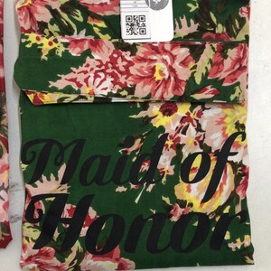 a green and pink flowered scarf with a tag on it