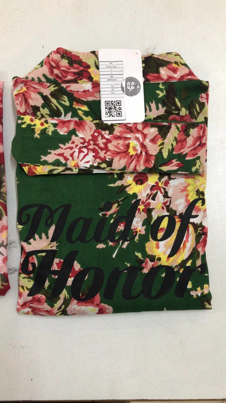 a green and pink flowered scarf with a tag on it