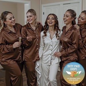 Op de afbeelding: Een groep vrouwen in bijpassende satijnen pyjama's. De pyjama's zijn bruin van kleur met witte biezen. Eén vrouw draagt een witte pyjama. De pyjama's zijn overhemden met knopen en broeken. De afbeelding bevat een afbeelding met de tekst "DUTY PAID (DDP)".