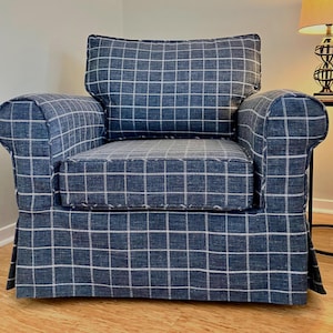 May include: A blue and white plaid armchair with a matching cushion. The chair has a tufted seat and a skirt.