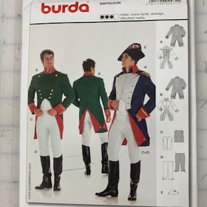 May include: A white ceramic mug with a black handle and the text "But First, Coffee" in a bold, black font. The mug is set against a blurred background, highlighting its clean design.