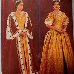 May include: A sewing pattern envelope featuring two variations of a floor-length gown. One version includes a deep red velvet-style robe with white faux fur trim and black accents, while the other shows a gold textured gown with puff sleeves.
