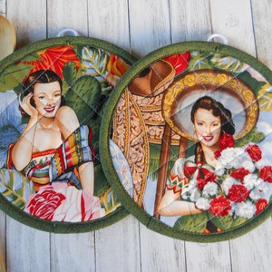 May include: Two round green pot holders with a quilted design. Each pot holder features a vintage illustration of a woman in a traditional Mexican dress. One woman is holding a bouquet of flowers, and the other is leaning against a cactus.