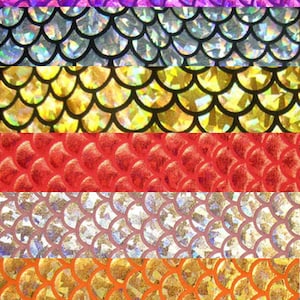 Pu&ograve; includere: Un primo piano di un tessuto iridescente con un motivo a squame in vari colori, tra cui turchese, viola, argento, oro, rosso, rosa, arancione, verde e giallo.