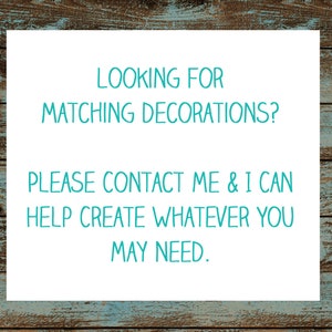 Op de afbeelding: Een wit bord met turquoise tekst dat zegt: "LOOKING FOR MATCHING DECORATIONS? PLEASE CONTACT ME & I CAN HELP CREATE WHATEVER YOU MAY NEED."