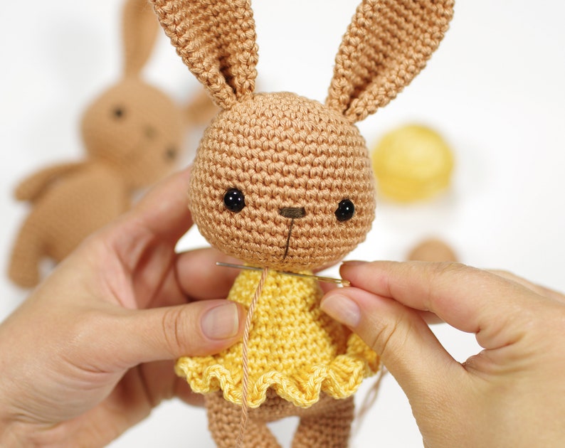 Sewing together a crocheted toy bunny