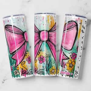 May include: Three white stainless steel tumblers with a pink bow design, floral accents, and the text "She is worthy" and "Proverbs 31". The tumblers have a colorful, abstract background with teal, yellow, and pink hues.