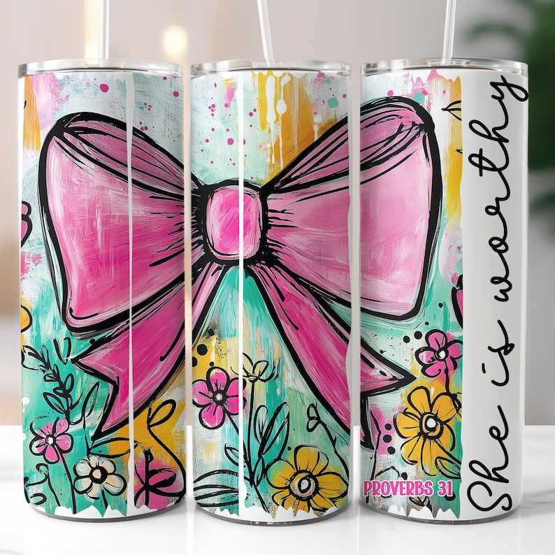 May include: A tumbler with a vibrant design featuring a large pink bow, flowers, and the text "She is worthy." The design includes a mix of teal, yellow, and white colors, with the words "Proverbs 31" at the bottom. The tumbler has a straw.