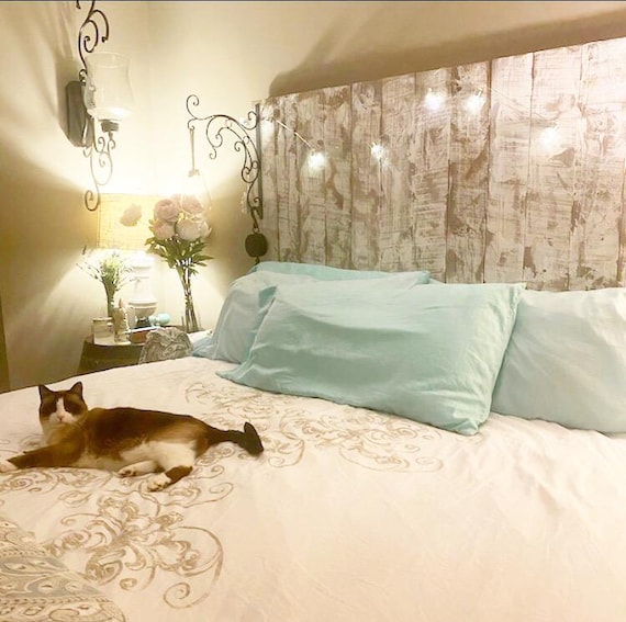 vintage lace overlay on whitewashed wooden headboard cottage style