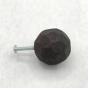 May include: A dark brown, faceted, round cabinet knob with a silver screw.