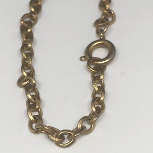 May include: Gold chain necklace with a lobster clasp closure.